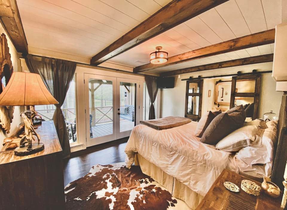 Bedroom with large windows and lake view in lakeside Airbnb outside Oxford, Mississippi.