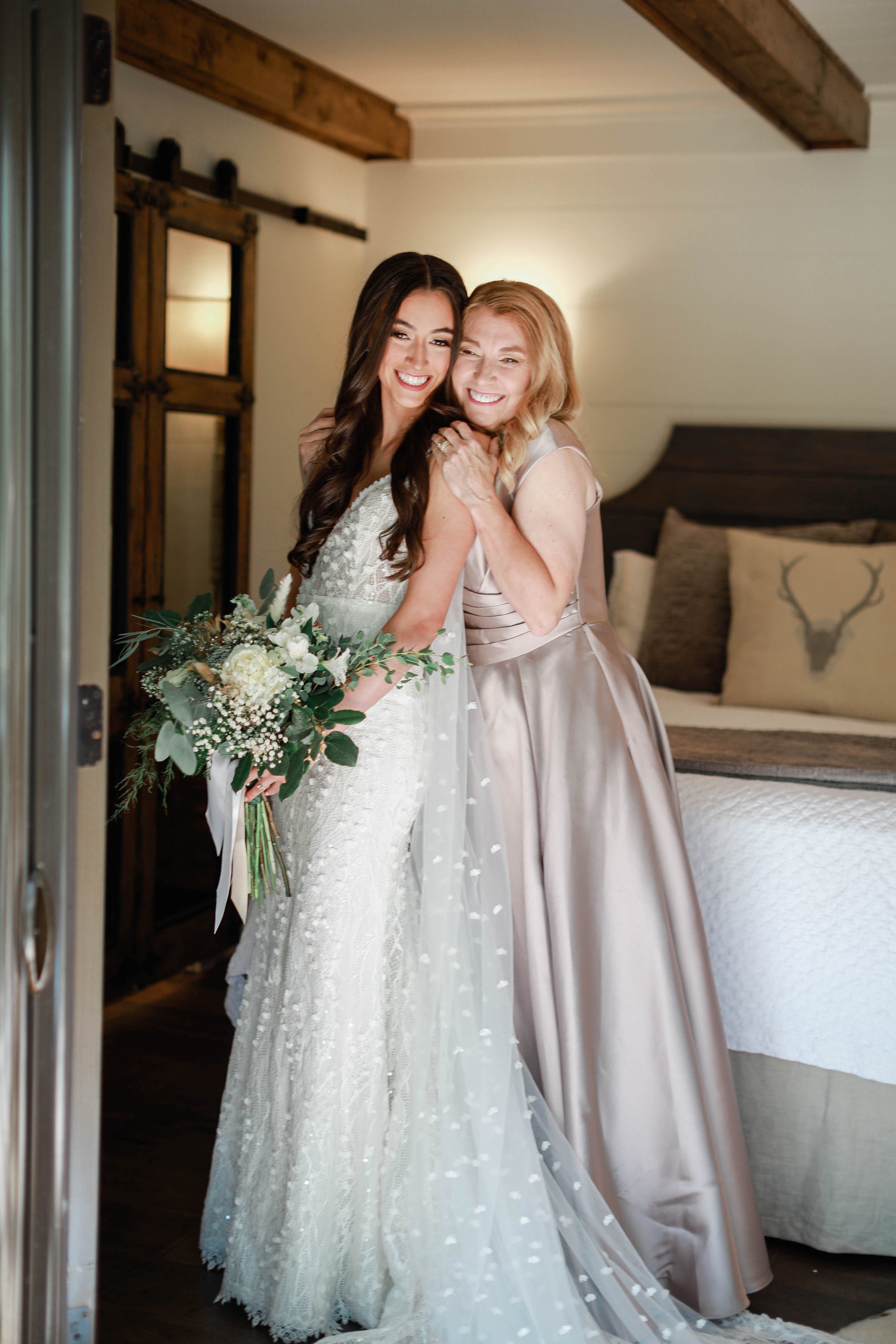 Bride hugging mother before ceremony in cabin at Brookwood Venue near Oxford, Mississippi.