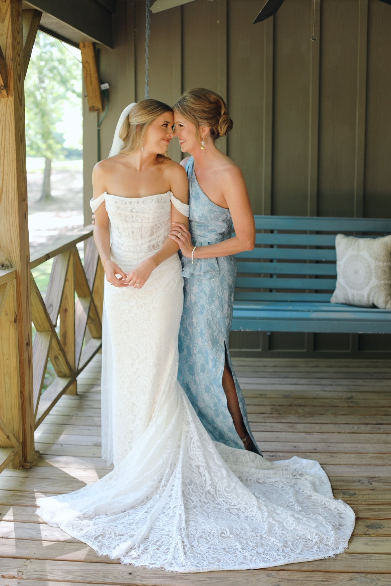 Candid moment of bride and mom smiling together during wedding prep in Brookwood Venue cabin