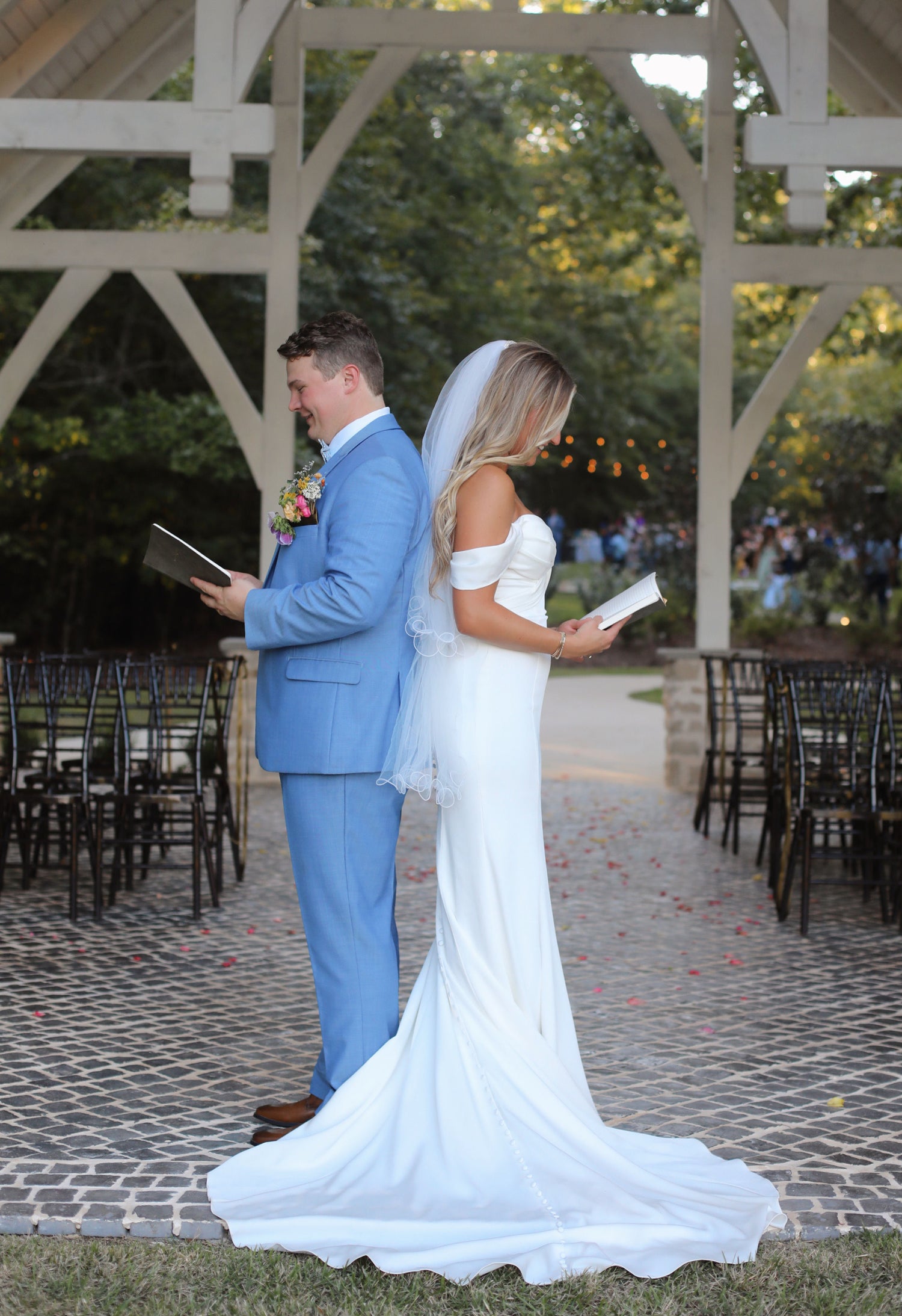 Couple reading wedding vows at lakeside chapel during golden hour near Oxford, Mississippi
