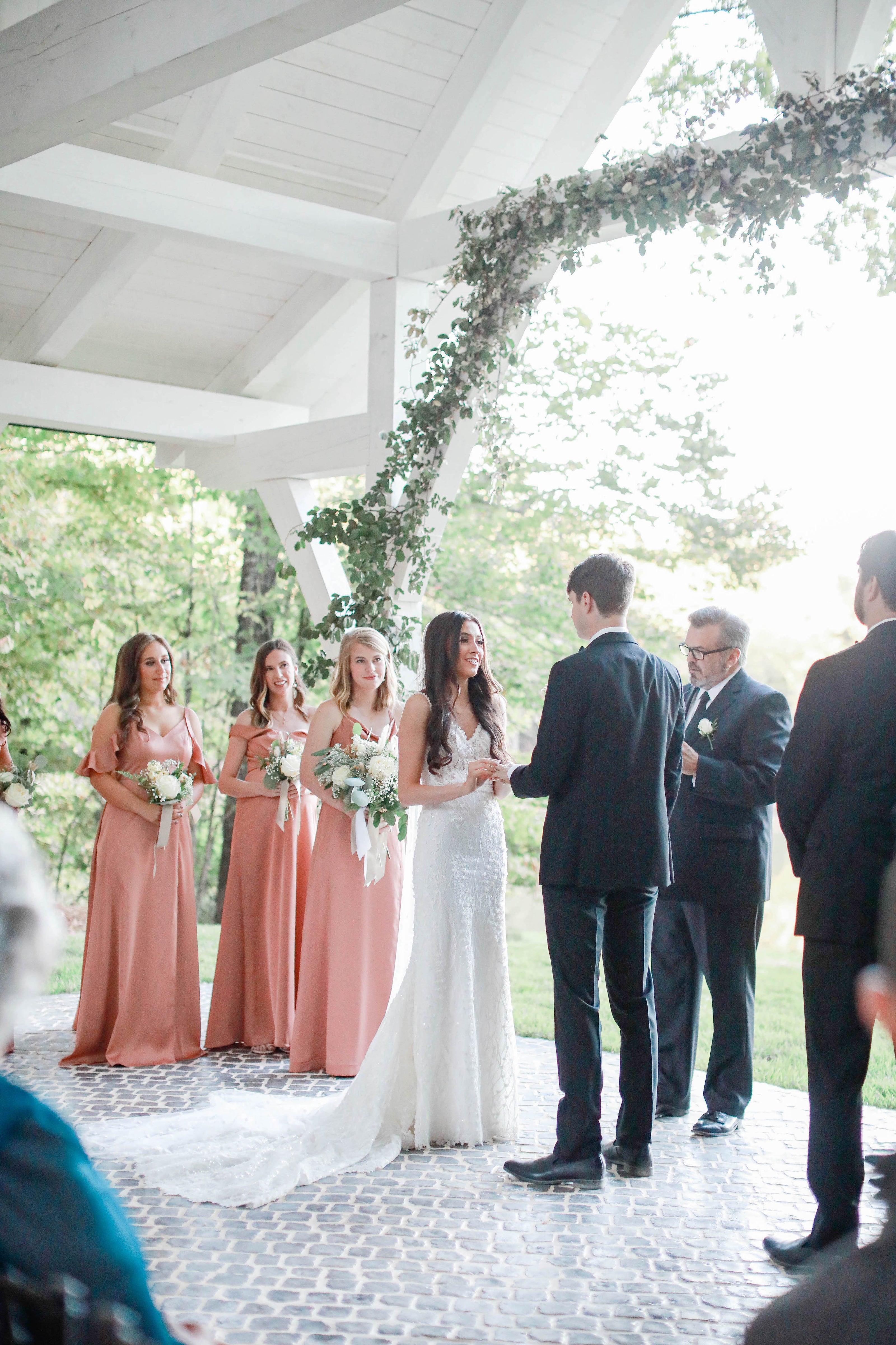 Bride and groom holding hands at altar in Brookwood Venue lakeside chapel.