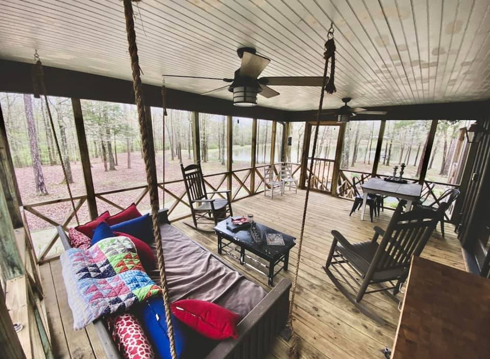 Spacious screened-in porch with rustic furniture at Brookwood Venue, perfect for wedding prep and family in Oxford, MS.