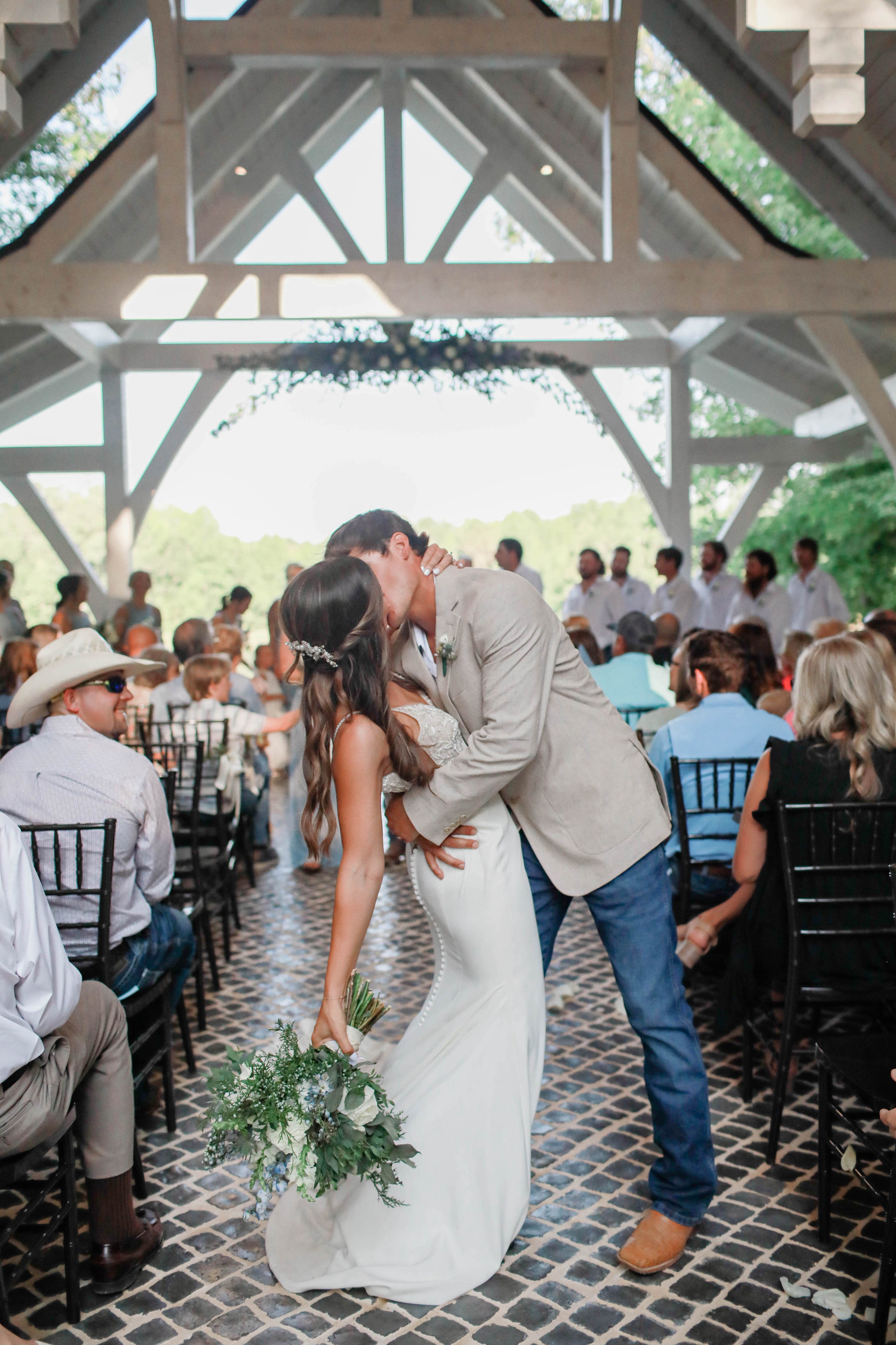 Bride and groom kissing in the aisle at Brookwood Venue near Oxford, Mississippi
