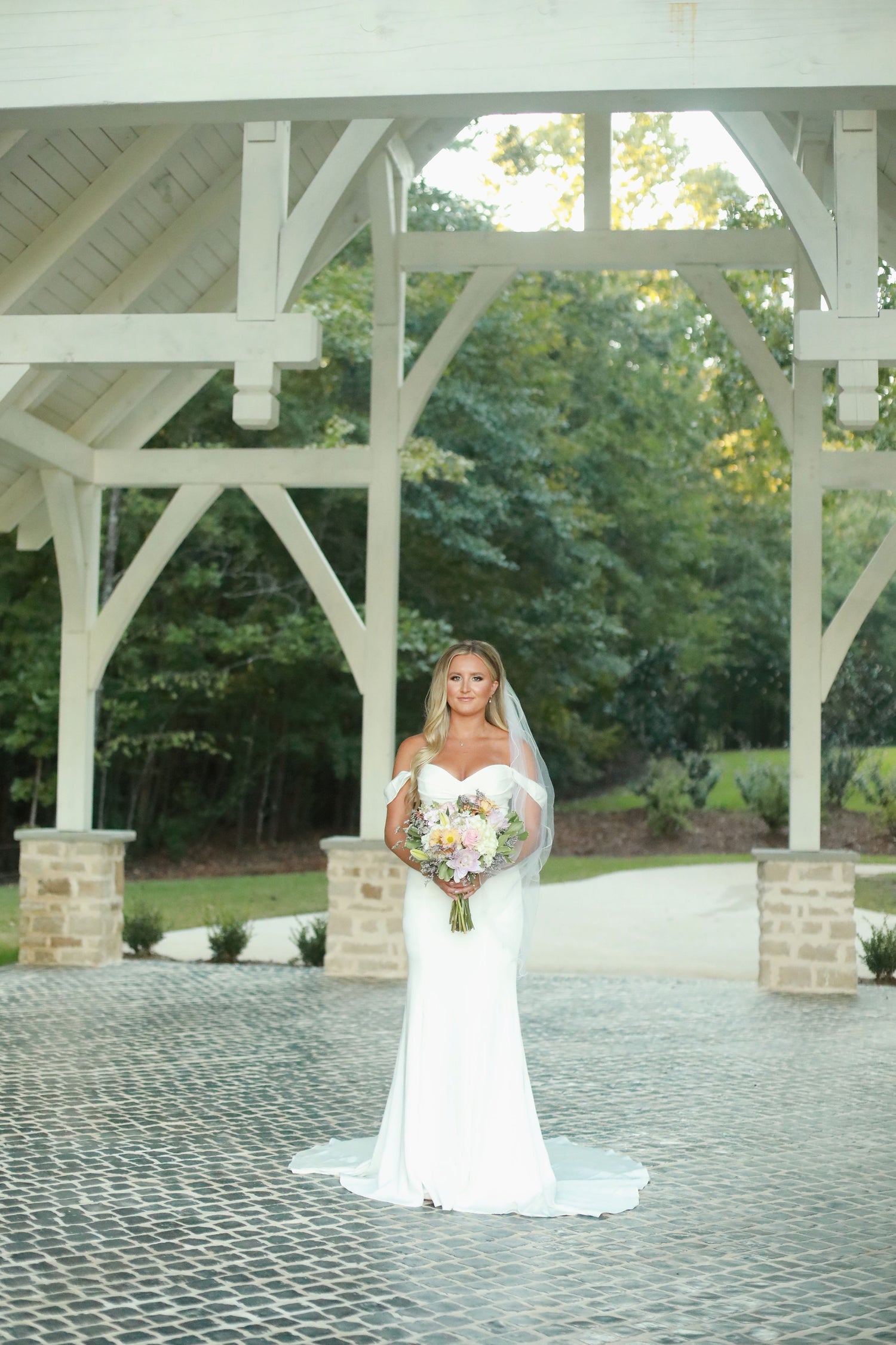 bridal portraits under a white wooden chapel at wedding venue in bruce, mississippi