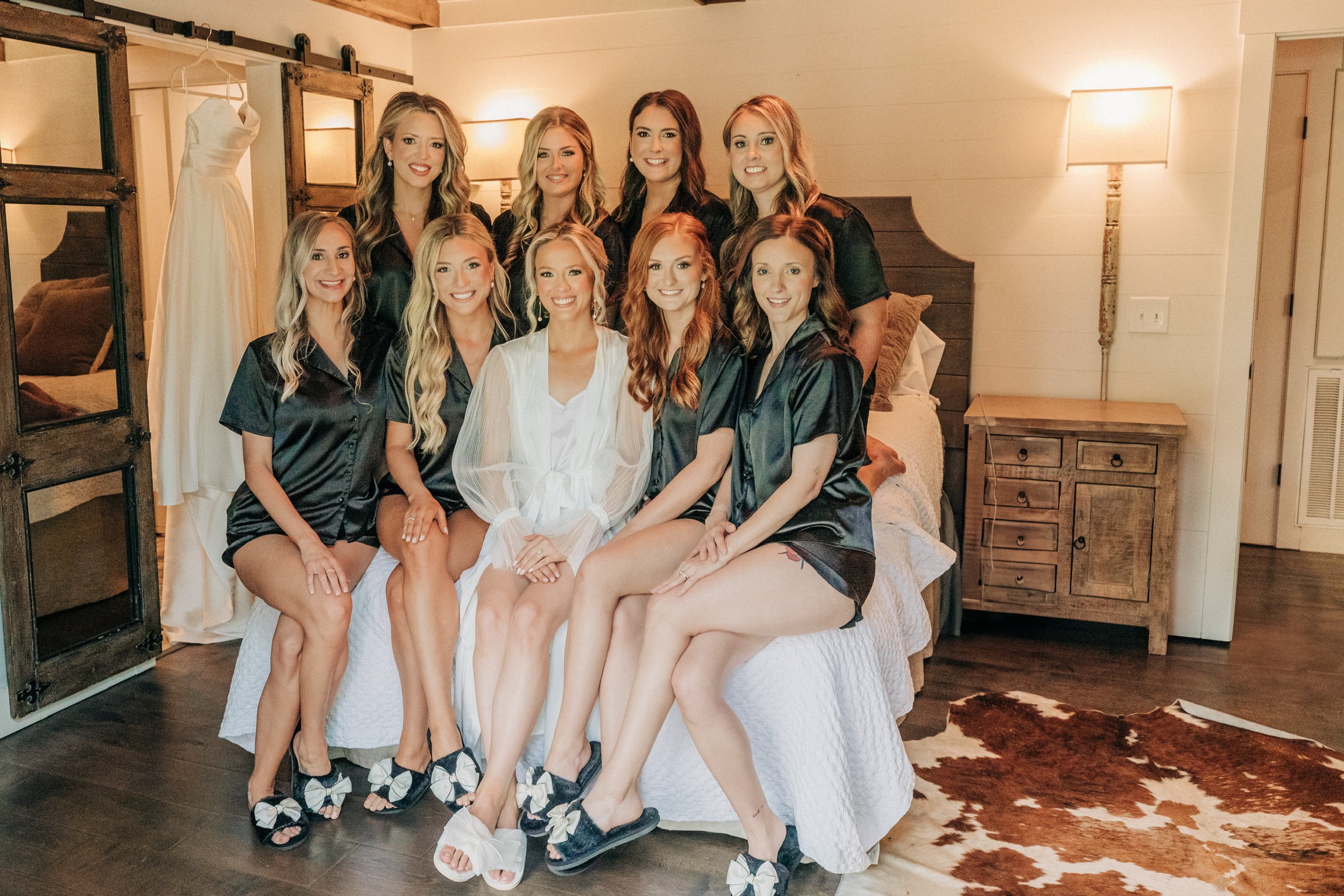 Bride and bridesmaids sitting for photos in bridal suite at Brookwood Venue near Oxford, MS