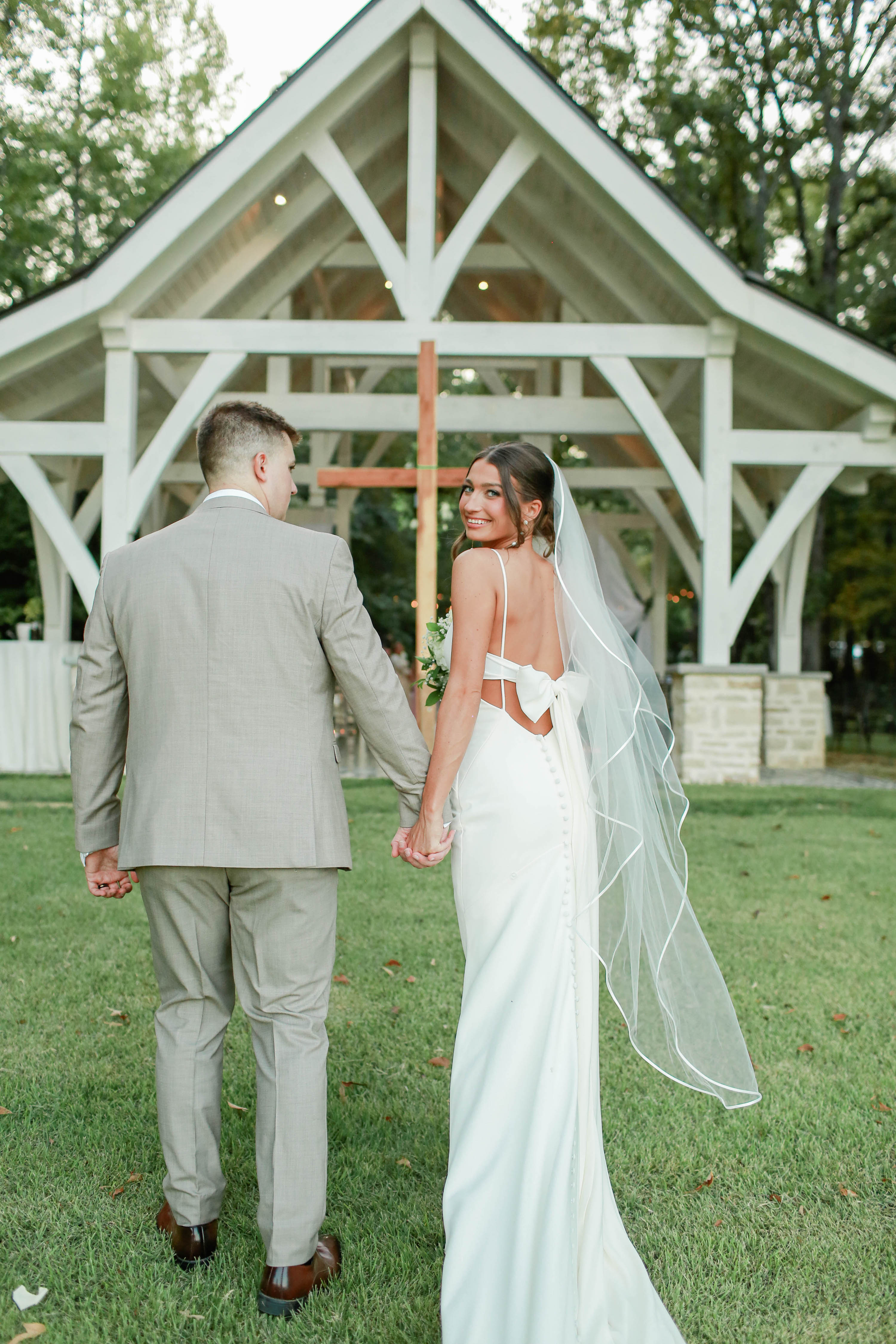 Bride and groom walking hand in hand at Brookwood Venue countryside wedding
