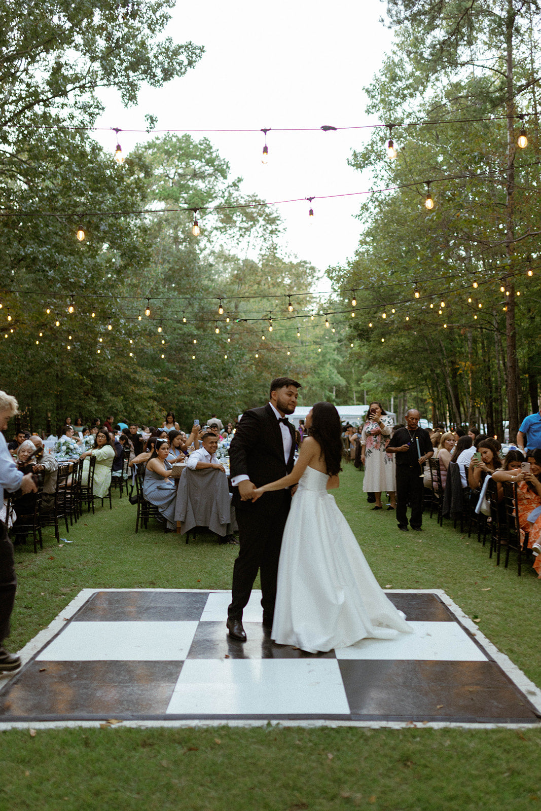 First dance on black and white dance floor with twinkle lights at Brookwood Venue near Oxford, MS."