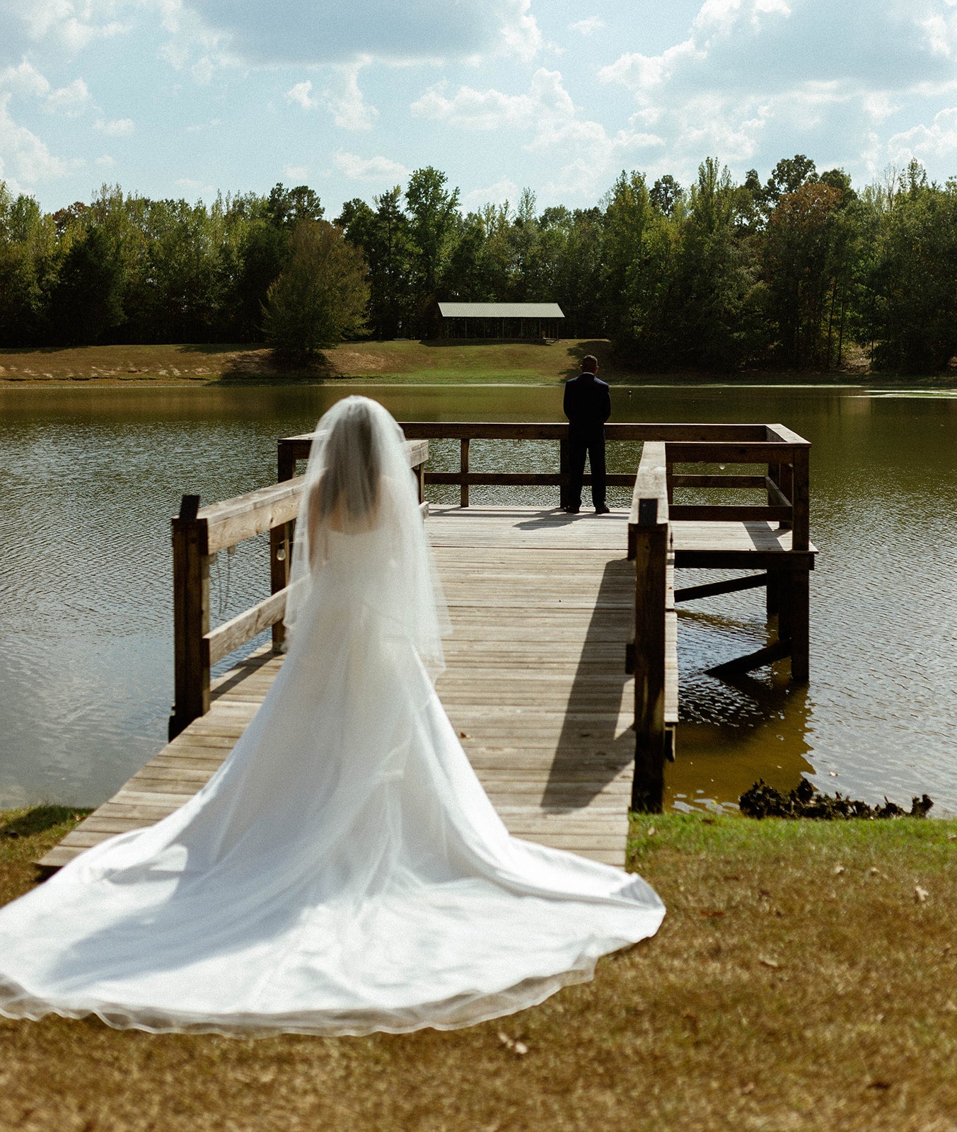bride's first look with her dad on a dock at private wedding venue in bruce, mississippi