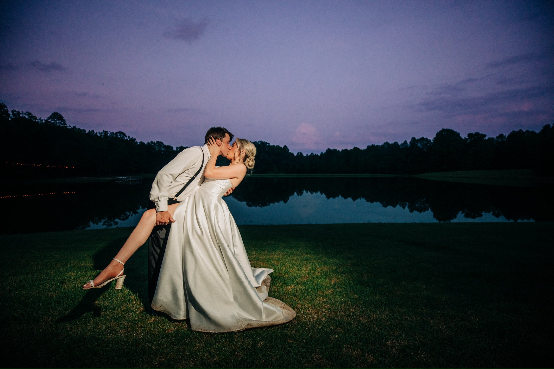 Bride and groom kissing by lake at Brookwood Venue near Oxford, Mississippi