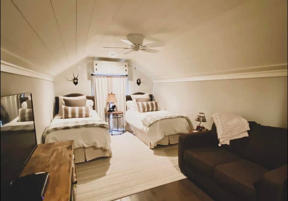 Bedroom with large windows and lake view in lakeside Airbnb outside Oxford, Mississippi.