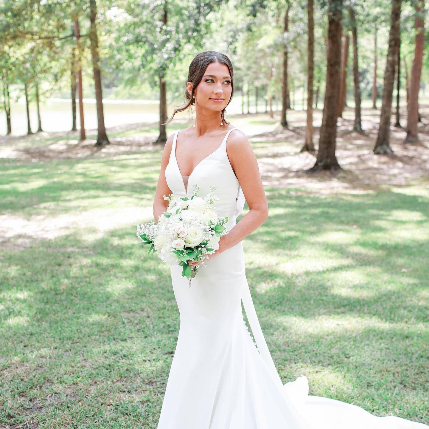 Bride holding bouquet in countryside setting at Brookwood Venue near Oxford, MS
