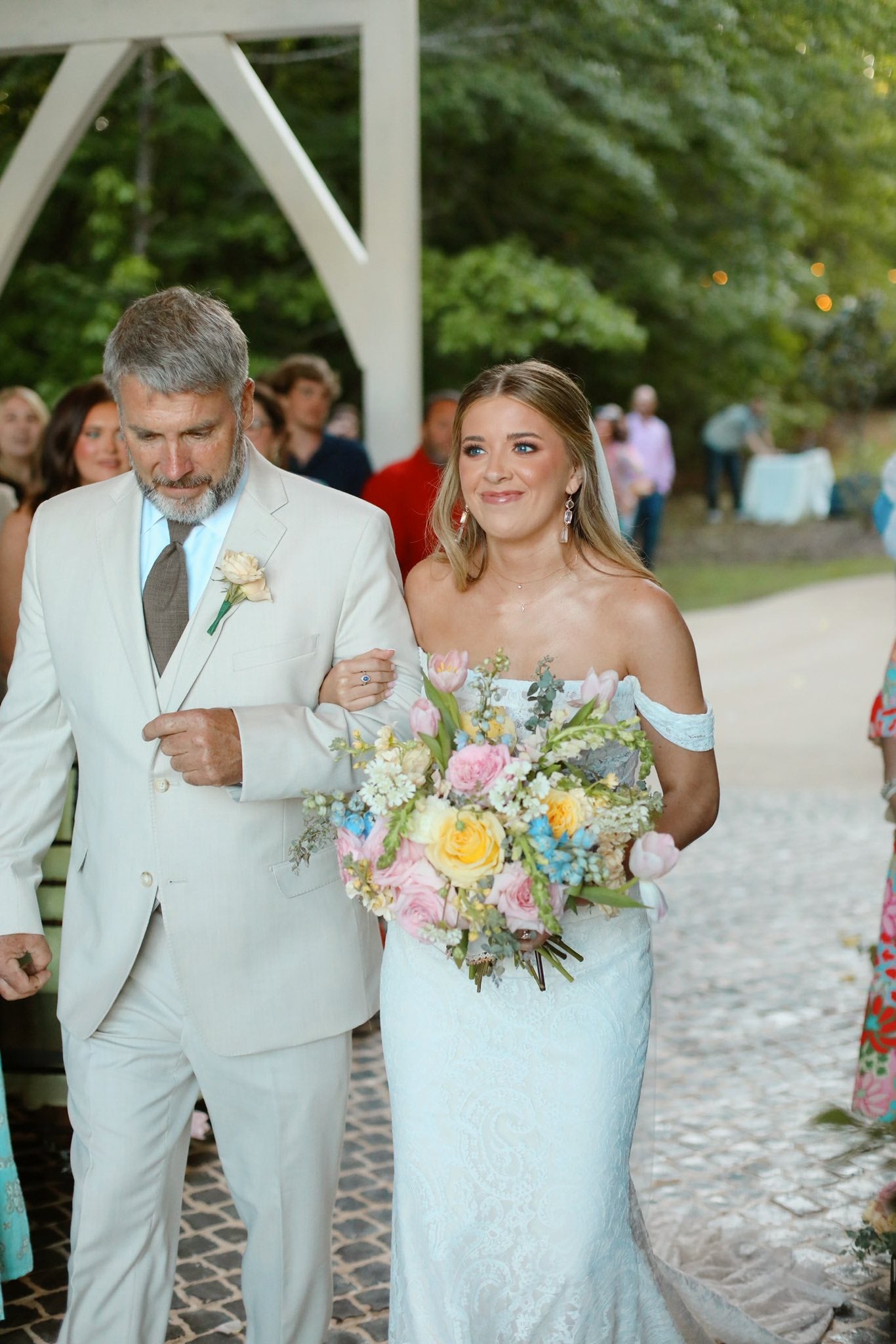 bride holding bouquet with father walking down aisle at Brookwood Venue chapel.