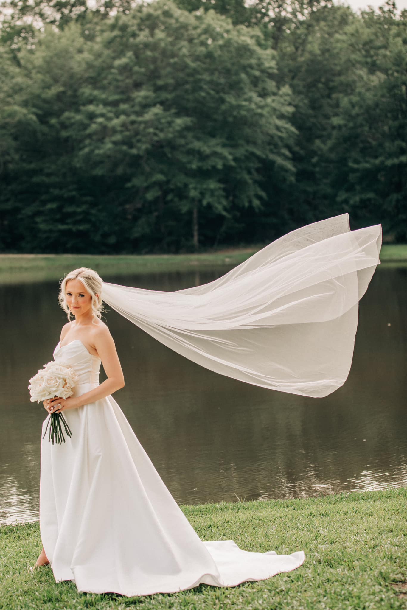 Bridal portrait with flowing veil at Brookwood Venue lakeside in North Mississippi.