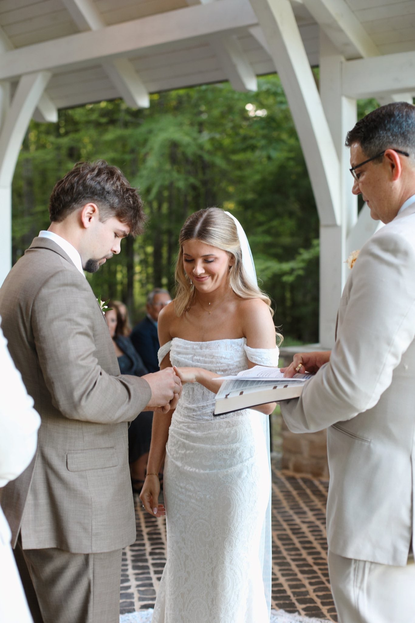 Wedding ceremony with a bride and groom exchanging vows under a outdoor chapel.