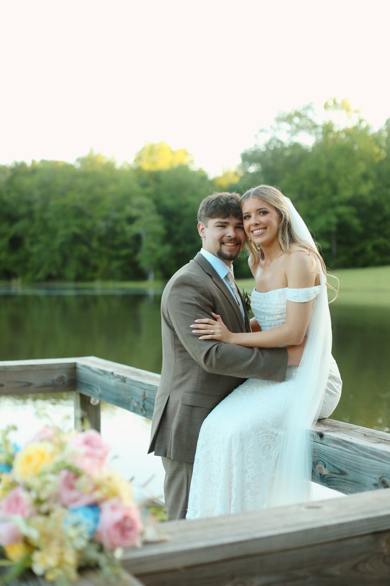 Couple embracing on dock at Brookwood Venue lake in North Mississippi