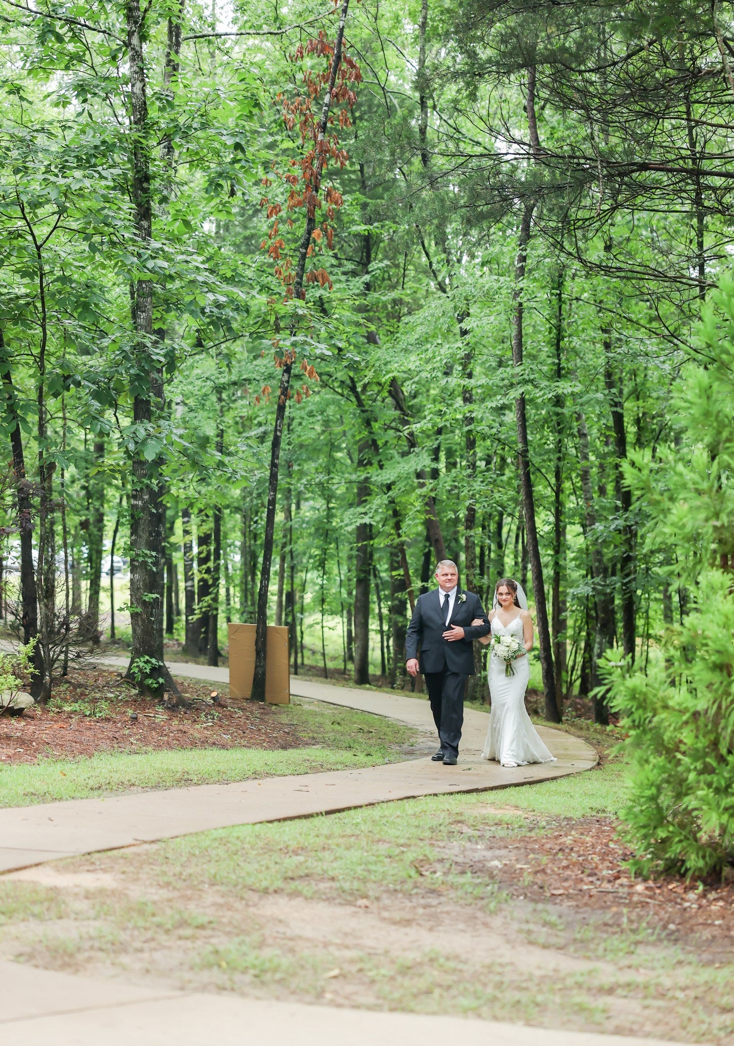 Father escorting bride down aisle at Brookwood Venue chapel at scenic wedding venue.