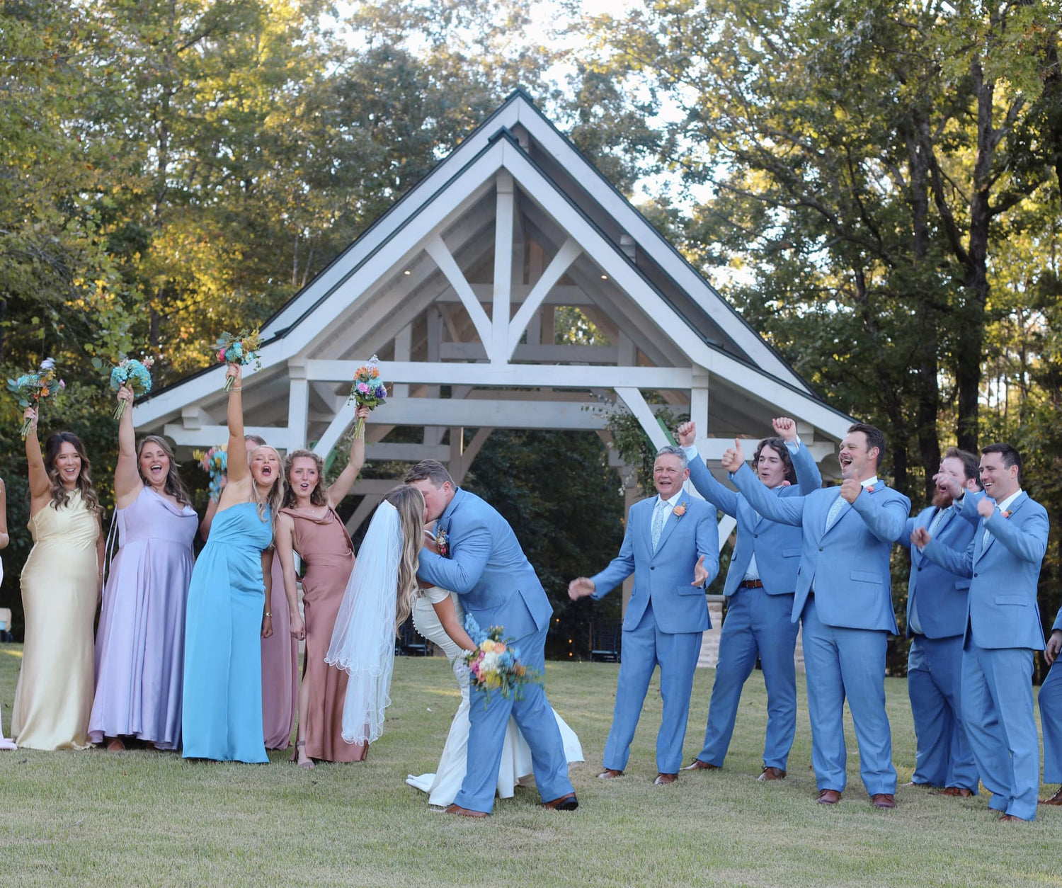 Wedding party celebrating outdoors with a wedding chapel in the background