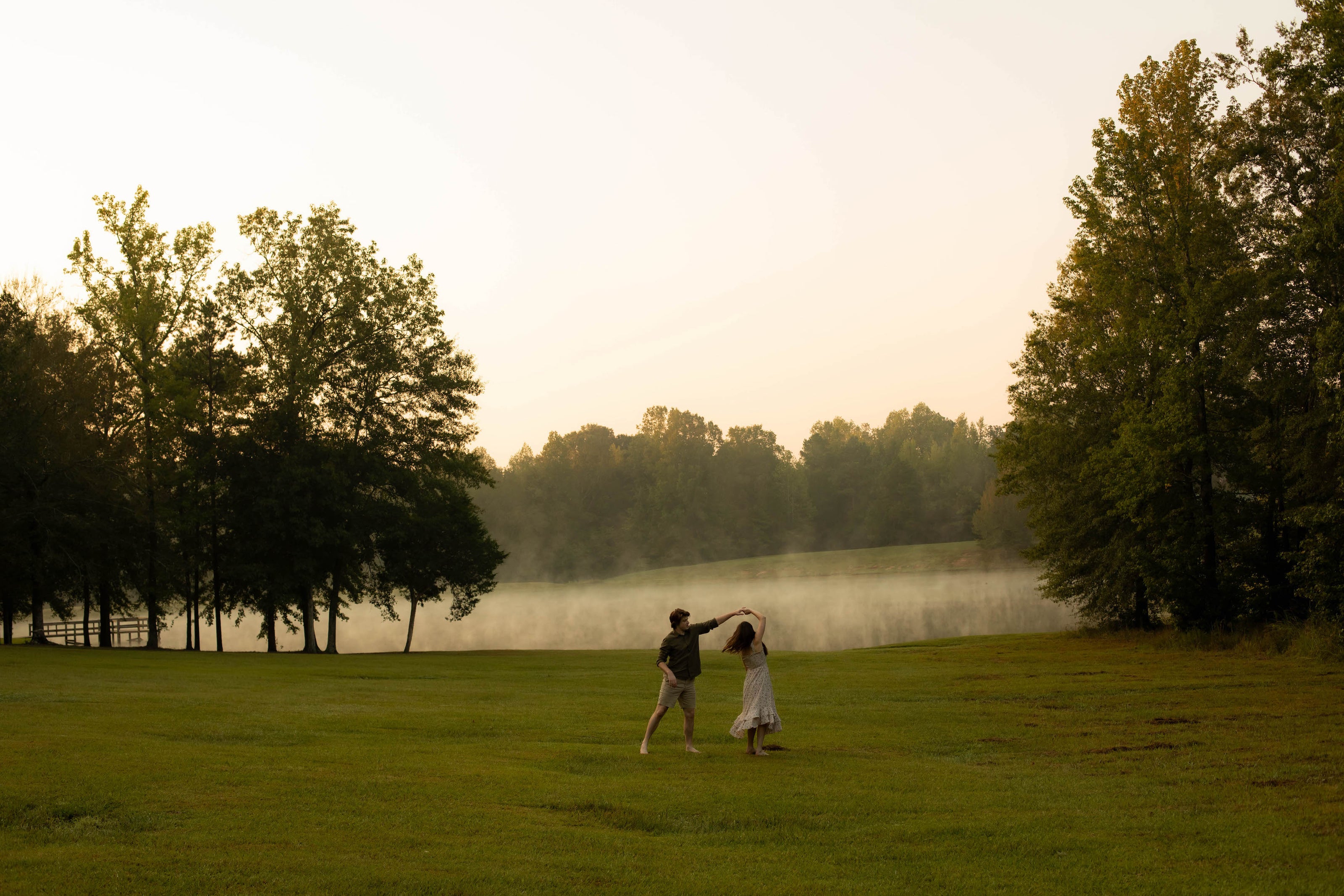 groom twirling bride along waterfront at Brookwood Venue near Oxford, MS.