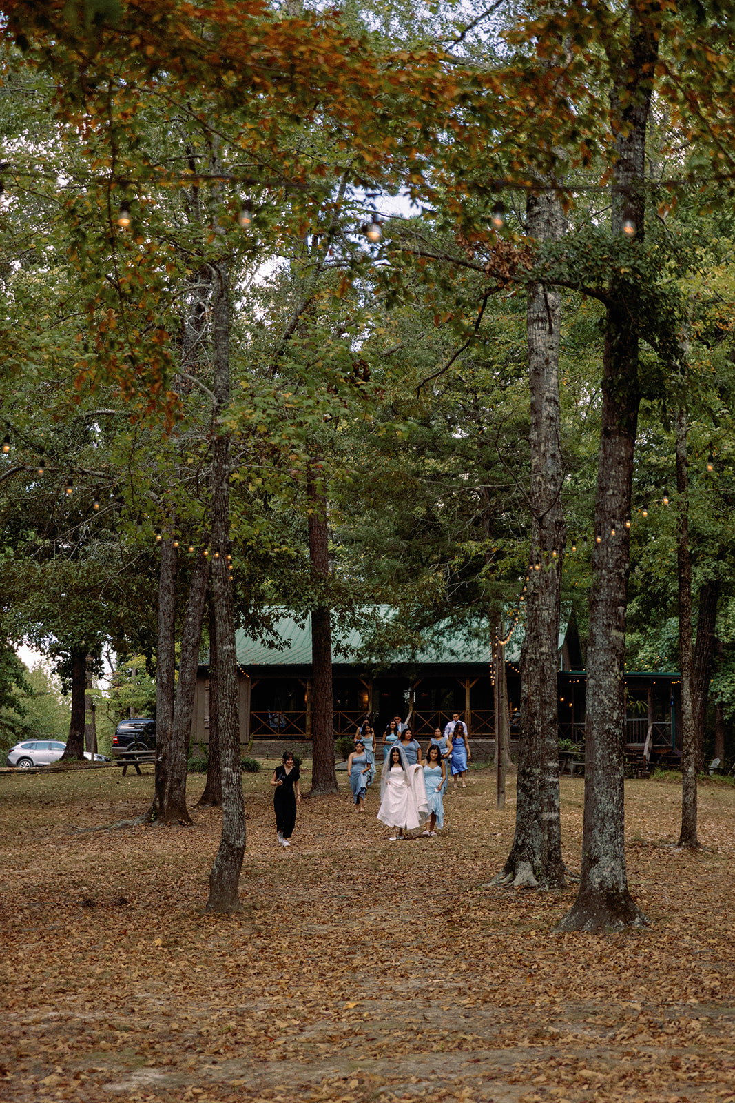 bride and bridal party walking through the woods to rustic wedding ceremony in North Mississippi