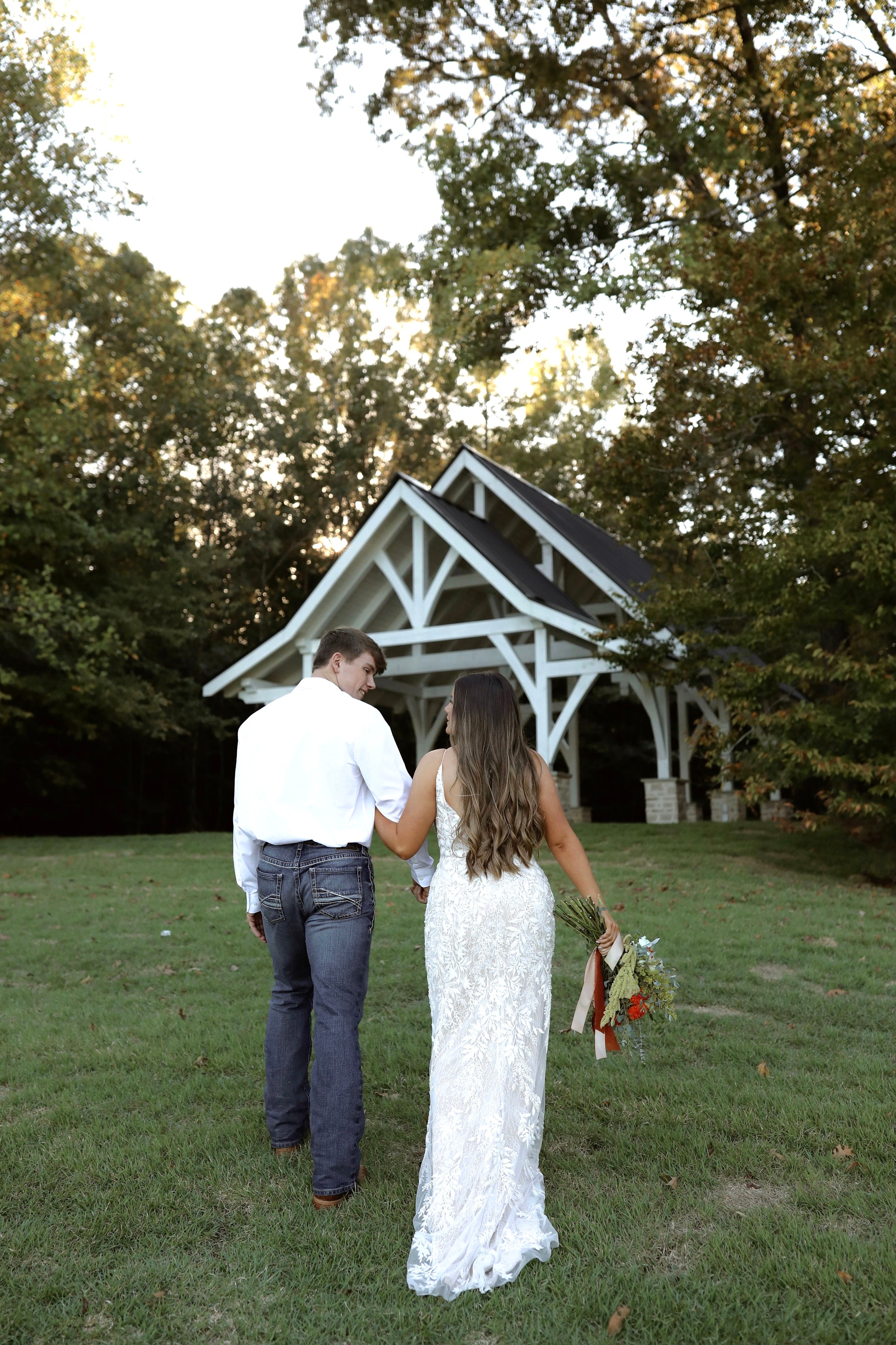 Bride and groom walking hand in hand at Brookwood Venue countryside wedding
