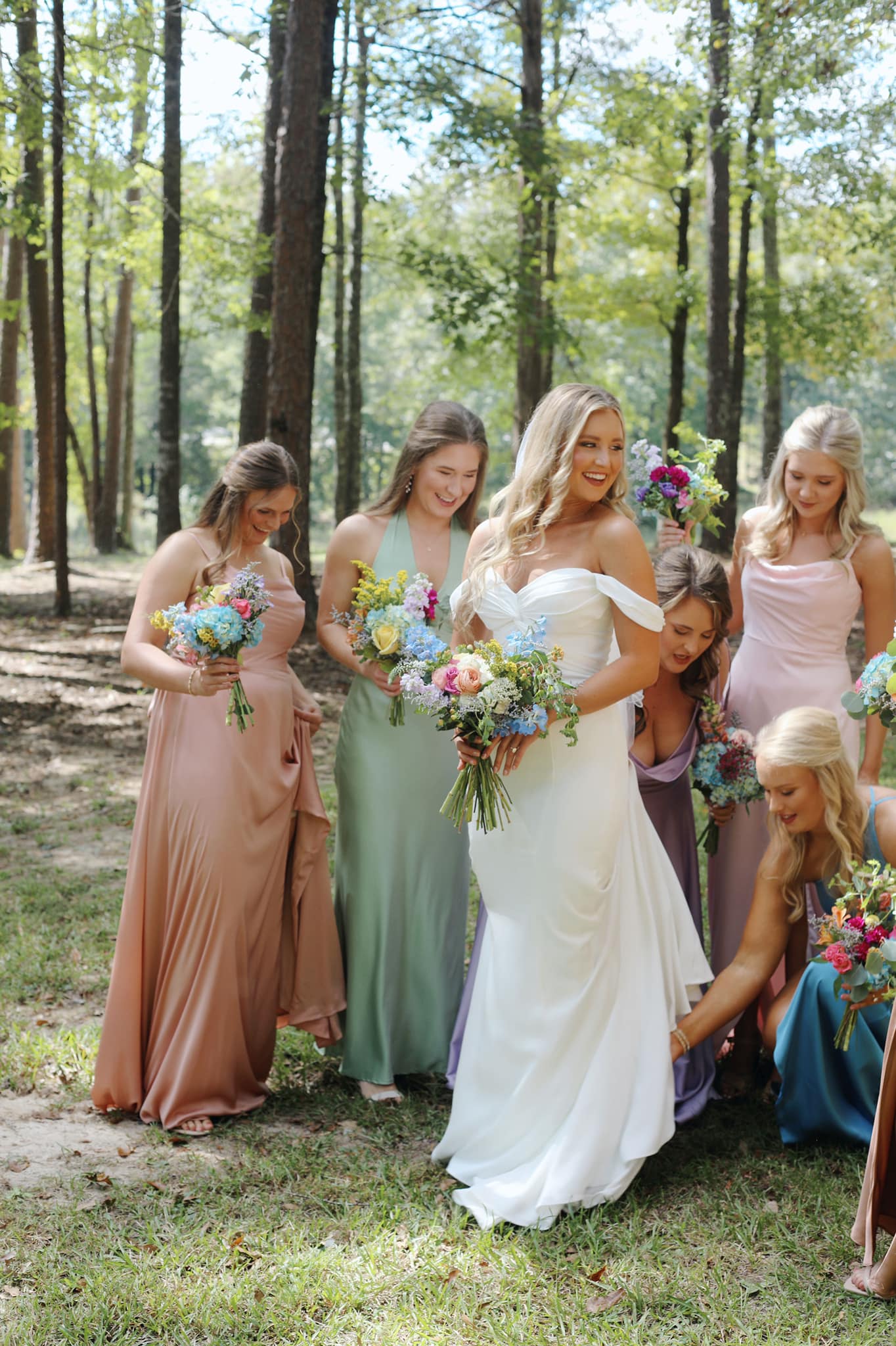 Bridesmaids helping bride with dress in North Mississippi wedding cabin