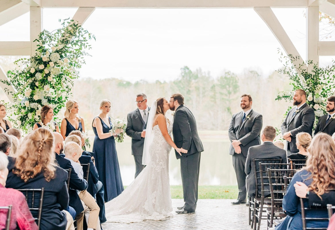 bride and groom sharing their first kiss at wedding ceremony in Bruce, Mississippi