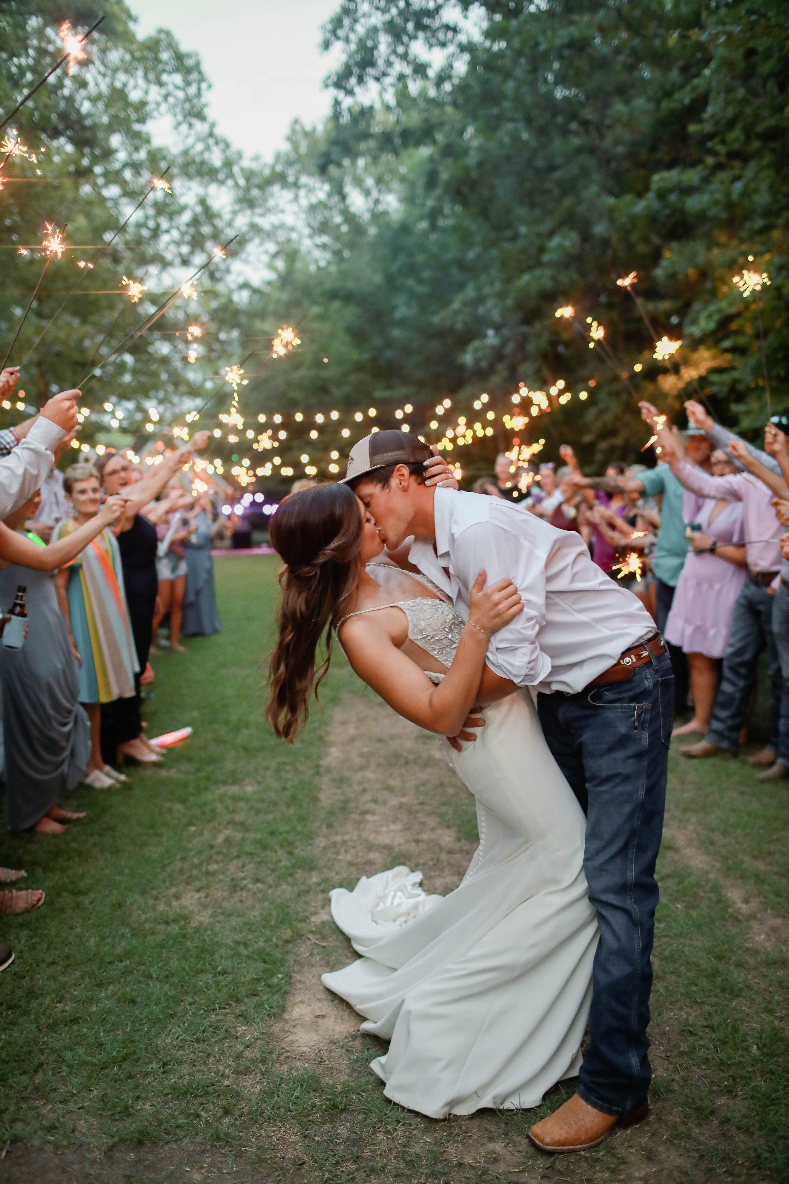 Couple exiting reception under lights at Brookwood Venue