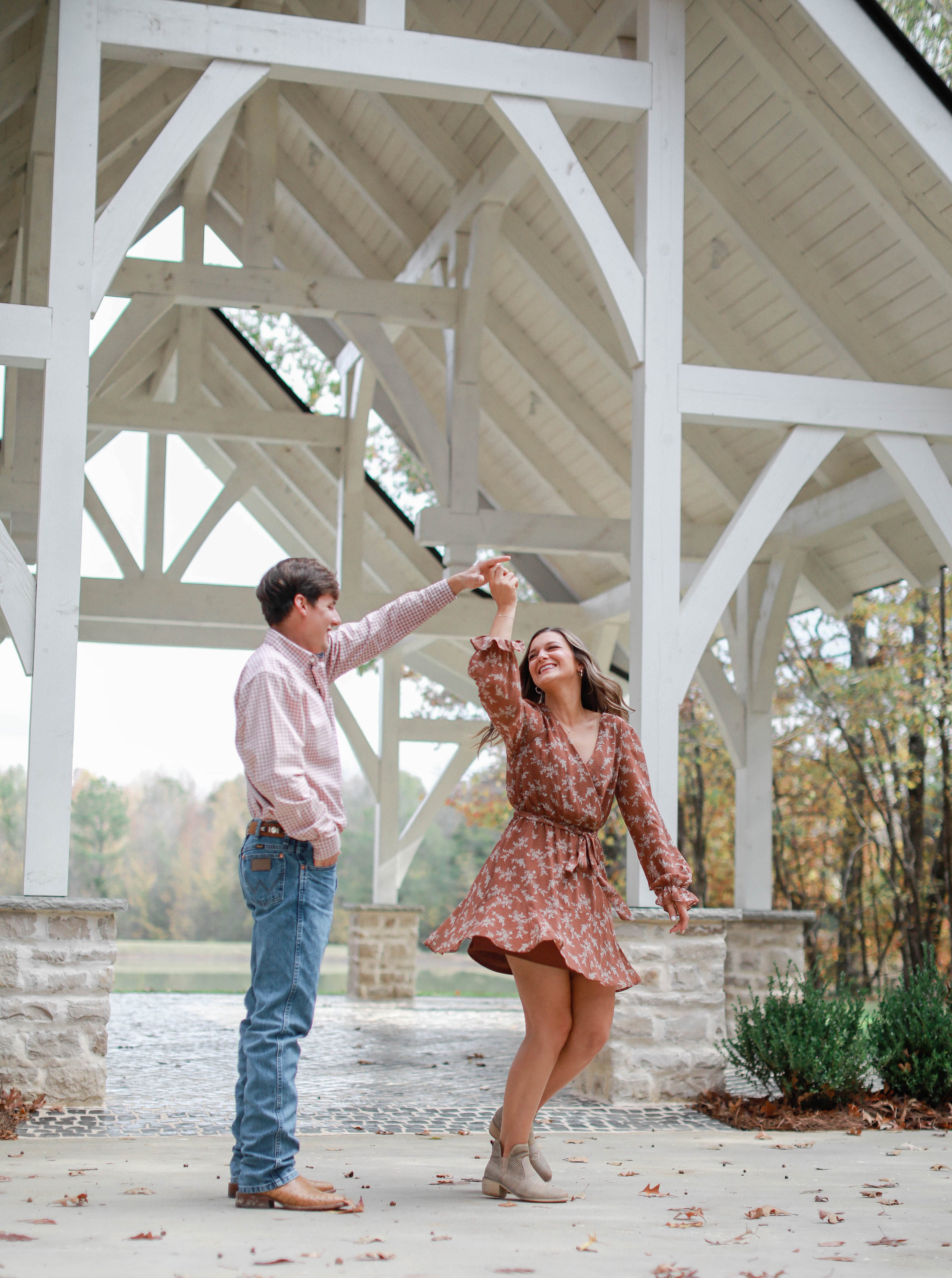 Bride and groom twirling by lake at Brookwood Venue in North Mississippi