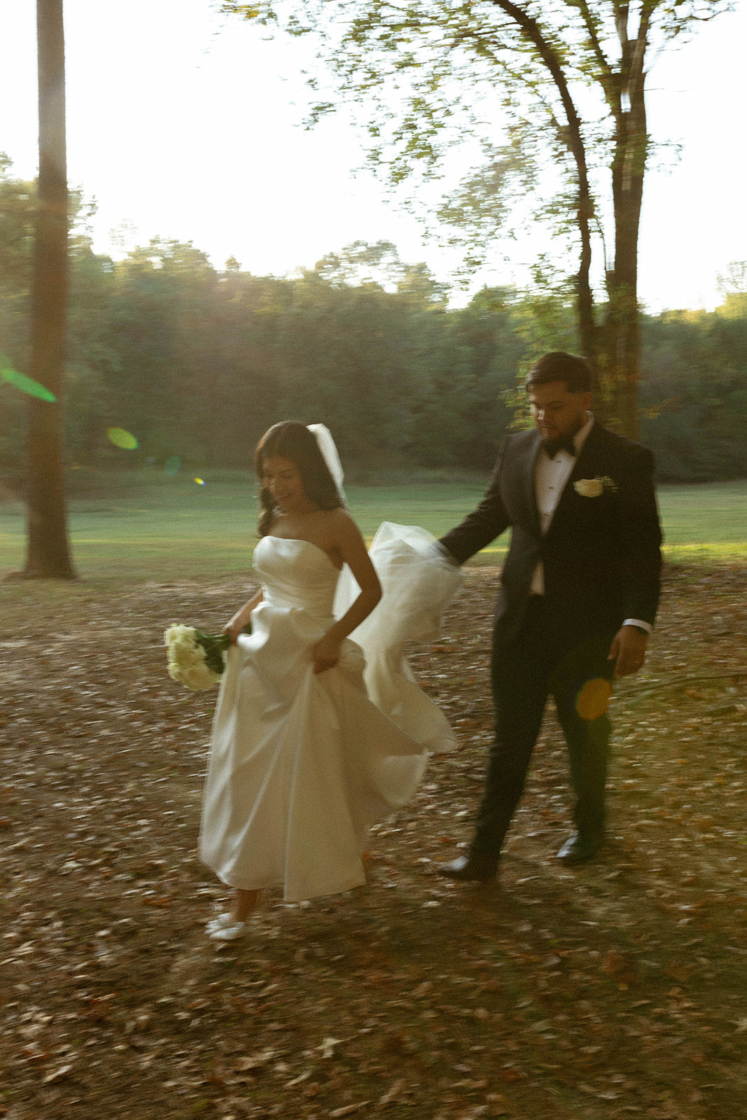 groom holding brides training while walking to wedding ceremony in bruce,ms